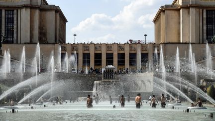 Des personnes tentent de se rafraîchir à la fontaine du Trocadéro, le 25 juillet 2018 à Paris.&nbsp; (BERTRAND GUAY / AFP)