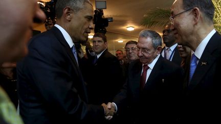 Barack Obama et son homologue cubain Raul Castro se serrent la main sous le regard du secr&eacute;taire g&eacute;n&eacute;ral de l'ONU Ban Ki-moon, vendredi 10 avril 2015 au Panama. ( AMR ABDALLAH DALSH / REUTERS)