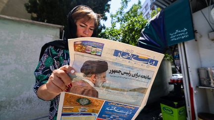 Une Iranienne lit un journal évoquant l'accident d'hélicoptère du président du pays, Ebrahim Raïssi, déclaré mort le 20 mai 2024. (ATTA KENARE / AFP)