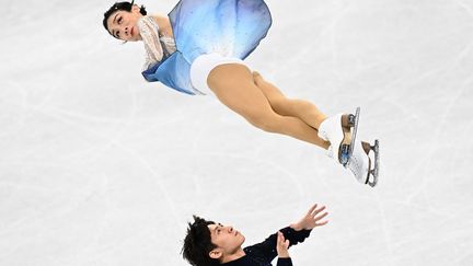 Sui Wenjing, en l'air, et&nbsp;Han Cong, qui la contemple, pendant le programme libre du patinage en couple, samedi 19 février.&nbsp; (ANNE-CHRISTINE POUJOULAT / AFP)