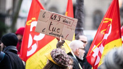 Une manifestante brandit une pancarte contre le recours à l'article 49.3 pour adopter la réforme des retraites, le 1er mars 2020, à Paris. (MAXPPP)