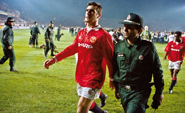 Eric Cantona est escort&eacute; hors du terrain &agrave; la suite de son expulsion lors du match Galatasaray-Manchester United, au stade Ali Sami Yen d'Istanbul (Turquie), le 3 novembre 1993.&nbsp; (TOM JENKINS / GETTY IMAGES EUROPE)