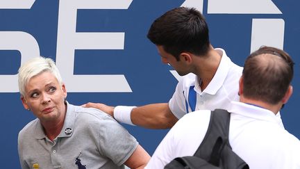 Novak Djokovic vient en aide à la juge qu'il a&nbsp;involontairement heurté en frappant une balle à l'US Open, le 6 septembre 2020 à New York. (AL BELLO / GETTY IMAGES NORTH AMERICA / AFP)