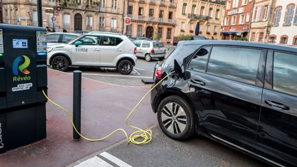 Une voiture est rechargée dans une borne en libre-service pour les véhicules électriques ou hybrides dans le centre ville de Toulouse, le 22 mai 2021. (FREDERIC SCHEIBER / HANS LUCAS  / AFP)