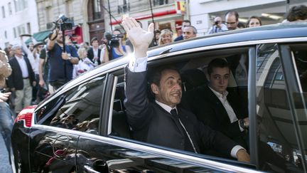 Nicolas Sarkozy et son fils Louis quittent le si&egrave;ge de l'UMP, le 8 juillet 2013. (FRED DUFOUR / AFP)