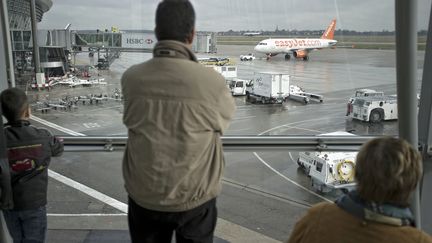 Passagers à l'aéroport de Lyon Saint-Exupéry devant le tarmac (JEAN-PHILIPPE KSIAZEK / AFP)