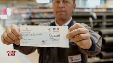 Alexandre de Cuniac, directeur g&eacute;n&eacute;ral de Leduc, avec son ch&egrave;que du tr&eacute;sor public pour le CICE. L'Angle &eacute;co, septembre 2015. ( CAPTURE ECRAN FRANCE 2)