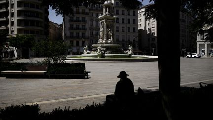 Un homme à la recherche d'un coin d'ombre à Lyon, alors qu'un épisode caniculaire touche l'Hexagone et la Corse, le 21 août 2023. (JEFF PACHOUD / AFP)