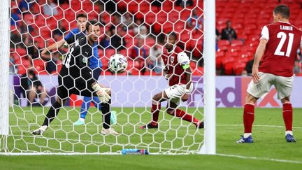 Le gardien de l'Autriche Daniel Bachmann s'incline en prolongation face à l'attaquant italien Federico Chiesa, le 26 juin 2021 à Londres. (CARL RECINE / POOL / REUTERS POOL)