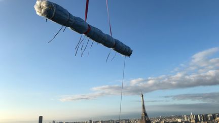 Un rouleau de tissu s'apprête à atterrir sur le sommet de l'Arc de Triomphe, samedi 11 septembre. (VALERIE GAGET / FRANCE TELEVISIONS)