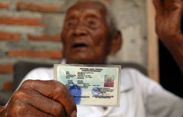 Mbah Gotto en train de montrer sa carte d'identité (le 29 août 2016). (AFP - ANADOLU AGENCY - DASRIL ROSZANDI )