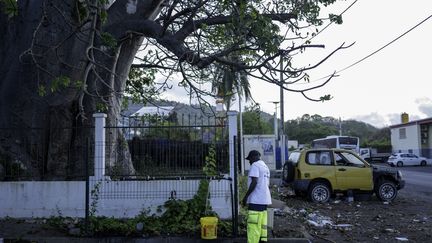 Un homme rempli son sceau d'eau à un point d'accès Dzaoudzi à Mayotte le 7 novembre 2023. (MARION JOLY / AFP)