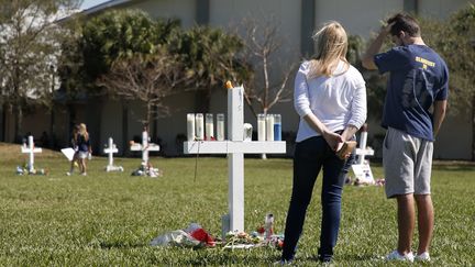 Des Américains rendent hommage aux victimes de la fusillade au lycée Stoneman Douglas de Parkland (Floride), le 16 février 2018. (RHONA WISE / AFP)