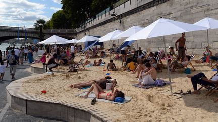 Des gens bronzent sur les berges de Seine, lors du troisi&egrave;me jour de l'op&eacute;ration "Paris plages", le 22 juillet 2015. (MIGUEL MEDINA / AFP)