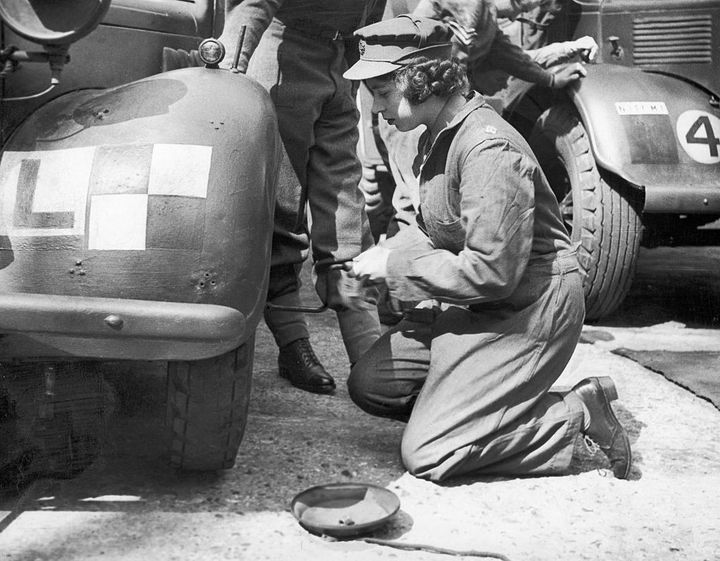 Elizabeth II apprend à réparer un camion lors de son passage dans l'armée britannique, le 12 avril 1945 au Royaume-Uni. (MIRRORPIX / GETTY IMAGES)