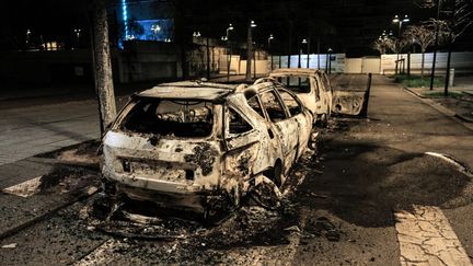 Des voitures brûlées dans le quartier Parilly à Bron (métropole de Lyon), le 6 mars 2021. (OLIVIER CHASSIGNOLE / AFP)