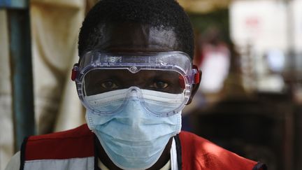 Un agent de santé portant une combinaison de protection dans le centre de depistage de Mpondwe, ville frontalière entre l'Ouganda et la RDC, le 13 juin 2019. (ISAAC KASAMANI / AFP)