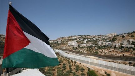 Le drapeau palestinien en face du "mur de séparation" en Cisjordanie (AFP)