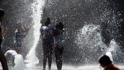 Des enfants jouant près d'une fontaine publique à Toulouse (Haute-Garonne), lors d'un épisode de fortes chaleurs, le 30 juillet 2020. (ALAIN PITTON / NURPHOTO)