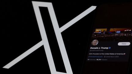 Le compte X de l'ancien président américain Donald Trump est affiché sur un smartphone et le logo de X est visible en arrière-plan à Ankara, en Turquie, le 25 août 2023. (MUSTAFA CIFTCI / ANADOLU AGENCY / AFP)