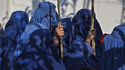 Des femmes afghanes portant une burqa font la queue pour recevoir une aide alimentaire à Kaboul, le 29 novembre 2021.&nbsp; (HECTOR RETAMAL / AFP)