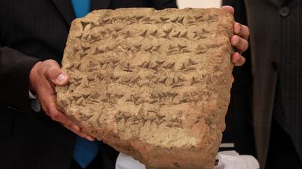 Une tablette de pierre vieille de 2 800 ans est présentée lors d'une conférence de presse à Bagdad, le 18 juin 2023. (MURTAJA LATEEF / AFP)