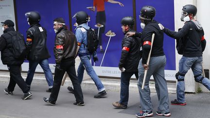 Des membres du service d'ordre de Force ouvrière se déplacent avec des manches de pioche, le 17 mai 2016, à Paris, lors d'une manifestation contre le projet de loi Travail. (THOMAS SAMSON / AFP)