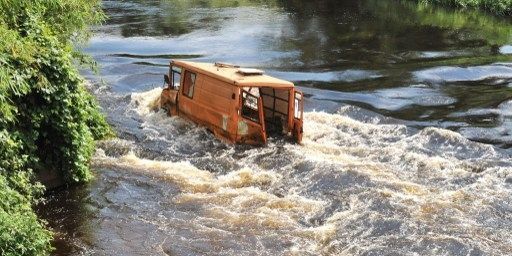 Un bus appelé «esprit de mort» par les Kinois, en raison de sa dangerosité, accidenté dans une rivière. (Junior D. Kannah / AFP)