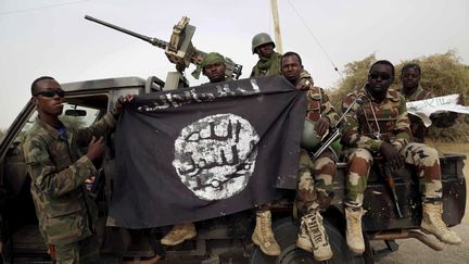 Des soldats nigérians brandissent un drapeau de l'organisation jihadiste Boko Haram à Damasak (nord-est du Nigeria), le 18 mars 2015. (REUTERS FILE PHOTO / X03763)