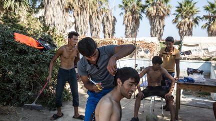 Un migrant se fait faire une coupe de cheveux improvis&eacute;e &agrave; l'h&ocirc;tel d&eacute;saffect&eacute;&nbsp;Captain Elias, devenu un refuge de fortune, le 19 ao&ucirc;t 2015. (KONSTANTINOS TSAKALIDIS / SOOC)