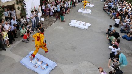 Des hommes d&eacute;guis&eacute;s en diable saute au-dessus de b&eacute;b&eacute;s lors du traditionnel festival "El Colacho" &agrave; Castrillo de Murcia (Esapgne), le 22 juin 2014. (CESAR MANSO / AFP)