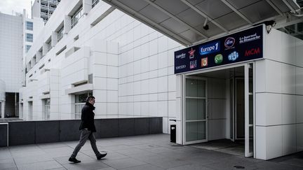 Un homme devant l'entrée du bâtiment du groupe Lagardère, où se trouve la rédaction d'Europe 1, en novembre 2018.&nbsp; (PHILIPPE LOPEZ / AFP)