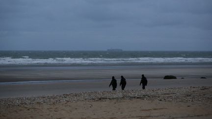 Trois policiers mrachent sur la plage à Wimereux, près de Calais (Pas-de-Calais), le 24 novembre 2021. (VALERIA MONGELLI / HANS LUCAS / AFP)