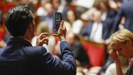 Un député prend l'Assemblée nationale en photo, lors de la séance inaugurale, le 27 juin 2017.&nbsp; (PATRICK KOVARIK / AFP)