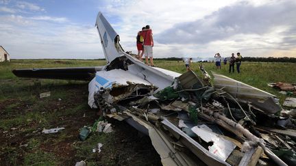 Des jeunes gens posent sur la carcasse d'un avion militaire ukrainien abattu par un missile russe pr&egrave;s du village de&nbsp;Davydo-Mykilske (Ukraine), le 14 juillet 2014. (DOMINIQUE FAGET / AFP)