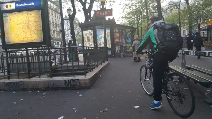 Kevin, livreur à vélo pour Take Eat Easy, patiente entre deux courses à la station de métro Bonne Nouvelle, à Paris. (JULIETTE DUCLOS / FRANCETV INFO)