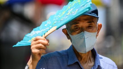 Un homme se protège de la chaleur lors d'un épisode caniculaire, à Séoul (Corée du Sud), le 16 août 2024. (ANTHONY WALLACE / AFP)