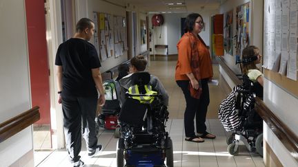 Des enfants en fauteuil roulant dans leur école près de Lyon, en septembre 2016.&nbsp; (PHILIPPE DESMAZES / AFP)