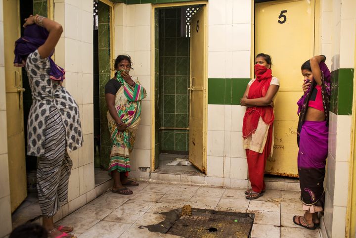 En Inde, les installations collectives sont une réponse à la pénurie de toilettes, mais sans système organisé pour le nettoyage et l'entretien, la défécation reste un problème de santé publique. Ici, des femmes attendent l'ouverture de la seule cabine en état de marche à New Delhi. (ANDREA BRUCE/ NOOR POUR NATIONAL GEOGRAPHIC MAGAZINE)