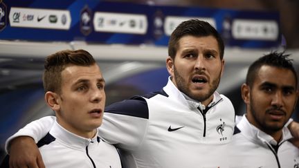 André-Pierre Gignac (ici entouré de Lucas Digne et Dimitri Payet) espère bien quitter le banc des remplaçants pour le poste de titulaire, face à l'Arménie.  (FRANCK FIFE / AFP)