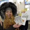 Une Ukrainienne montre une série de timbres achetés dans un bureau de poste de Kiev (Ukraine), le 6 décembre 2022. (RUSLAN KANIUKA / NURPHOTO / AFP)