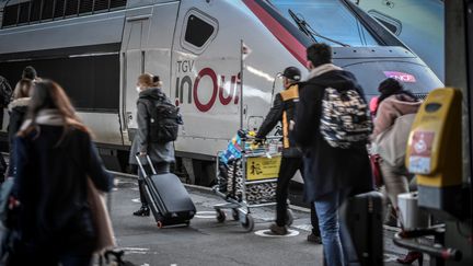 Des voyageurs marchent sur le quai de la Gare de Lyon avec leurs valises, en décembre 2020. (STEPHANE DE SAKUTIN / AFP)