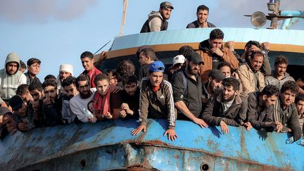 Des réfugiés et des migrants secourus  à bord d'un bateau dans la ville de Paleochora, au sud-ouest de l'île de Crète, le 22 novembre 2022 (COSTAS METAXAKIS / AFP)