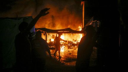 Cette photo fournie par l'Office de secours et de travaux des Nations Unies pour les réfugiés de Palestine dans le Proche-Orient (UNRWA) montre l'incendie d'un camp de déplacés, après une frappe israélienne sur l'hôpital al-Aqsa, le 14 octobre 2024. (AFP PHOTO / HO / UNRWA)