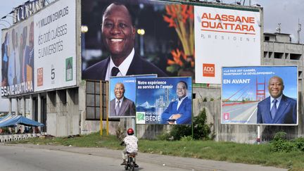 Cette photo prise le 23 octobre 2010 à Abidjan montre des affiches électorales représentant&nbsp;le président sortant&nbsp;Laurent Gbagbo (à droite et à gauche), l'ancien chef de l'Etat Henri Konan Bédié (au centre)&nbsp;et Alassane Ouattara (en haut, au fond), alors ancien Premier ministre, à la veille des élections présidentielles du 31 octobre. (SIA KAMBOU / AFP)