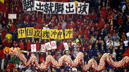 Les supporters chinois encouragent leur équipe nationale lors de son quart de finale de Coupe du monde féminine contre le Canada, le 2 octobre 2003 à Portland (Etats-Unis).&nbsp; (TOM HAUCK / GETTY IMAGES NORTH AMERICA)