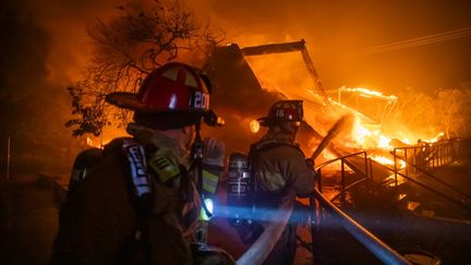 Des pompiers luttent contre les flammes du Palisades Fire, à Los Angeles, mercredi 8 janvier. Près de 1 400 pompiers sont actuellement mobilisés et des centaines d'autres sont en route, selon le gouverneur de Californie, Gavin Newsom. (APU GOMES / GETTY IMAGES NORTH AMERICA / AFP)