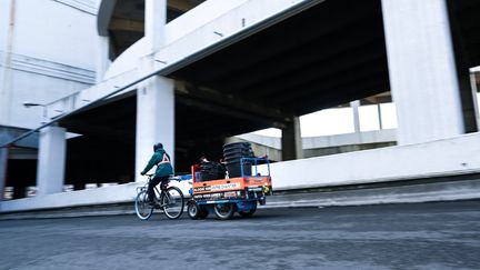 Un cycliste avec une remorque fournie par K-Ryole transporte un chargement. (K-Ryole)