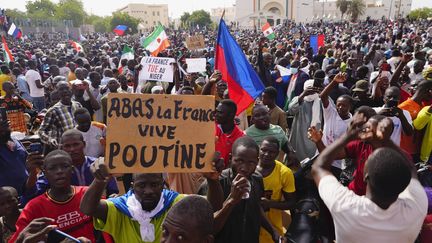 Des manifestants affichent une pancarte contre la France et pour le président russe, Vladimir Poutine, lors d'un rassemblement de soutien aux putschistes, à Niamey, au Niger, le 30 juillet 2023. (SAM MEDNICK / AP / SIPA)