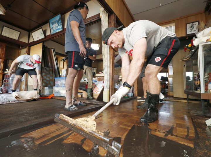 Des joueurs de rugby canadiens aident au nettoyage de la ville de&nbsp;Kamaishi (Japon) après le passage du typhon&nbsp;Hagibis, le 13 octobre 2019. (KYODO KYODO / REUTERS)